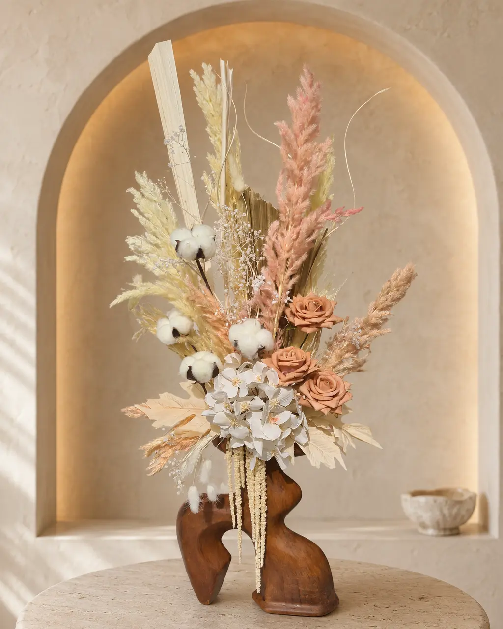 Ambre rosée, composition en fleurs séchées pêche et ivoire dans un vase en bois