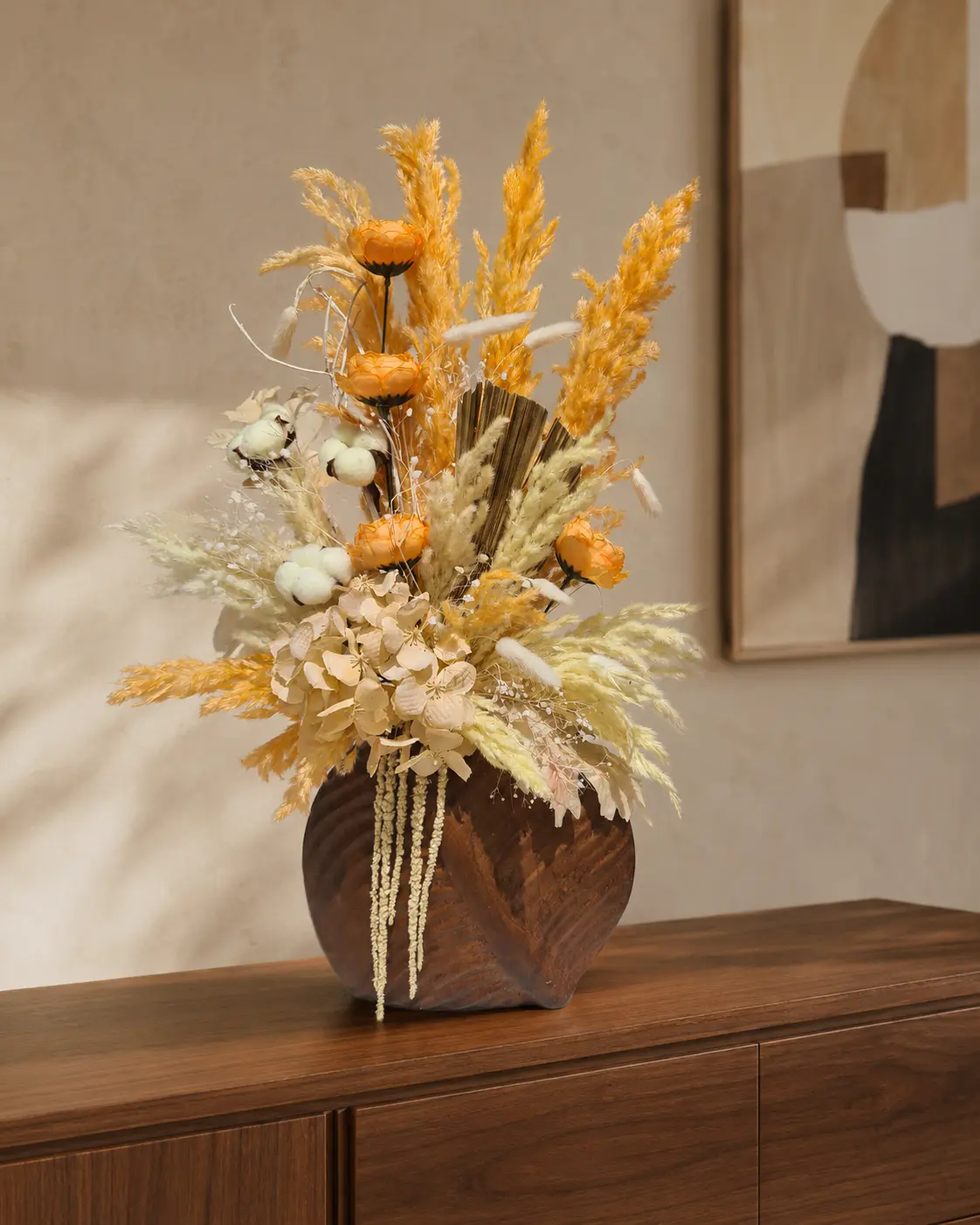 Soleil d’ambre, composition en fleurs séchées orange et crème dans un vase brun